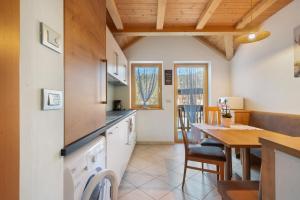 a kitchen with a table and a dining room at Kohlerhof Apartment in San Genesio Atesino