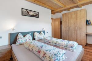 a bed with pillows on it in a bedroom at Kohlerhof Apartment in San Genesio Atesino