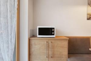 a microwave sitting on top of a wooden cabinet at Kohlerhof Apartment in San Genesio Atesino