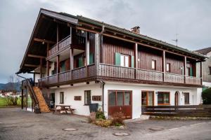a large wooden house with a balcony and a bench at Fewo in Urspring am Lechstausee in Steingädele