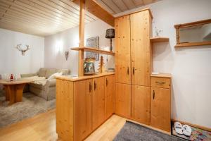 a kitchen with wooden cabinets and a living room at Fewo in Urspring am Lechstausee in Steingädele