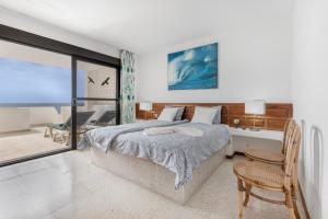 a bedroom with a bed and a table and a chair at Beach House Christine in Costa Calma