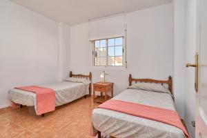 a bedroom with two beds and a window at Casa del mar Salobreña in Salobreña +24 photos