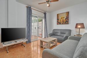a living room with a couch and a flat screen tv at Casa del mar Salobreña in Salobreña