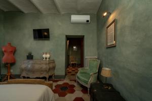 a bedroom with a bed and a chair and a table at L'imbrunire in Campiglia dʼOrcia
