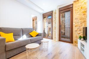 a living room with a gray couch and yellow pillows at Casa del Campanar in Traiguera