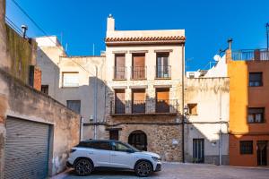 a white car parked in front of a building at Casa del Campanar in Traiguera