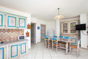 a kitchen and dining room with a table and chairs at Pavoncella in Orosei