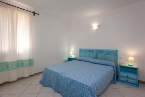 a bedroom with a blue bed and two night stands at Pavoncella in Orosei