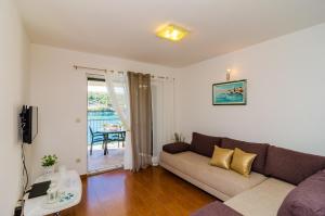 una sala de estar con un sofá y una mesa en Apartments Regina Maris, en Klek