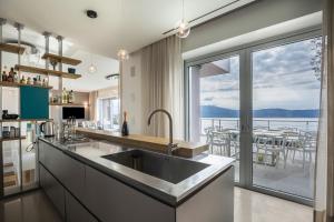 a kitchen with a sink and a large window at Villa Agave exclusive pool in Toscolano Maderno