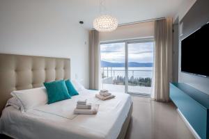a bedroom with a large bed with a large window at Villa Agave exclusive pool in Toscolano Maderno +39 photos