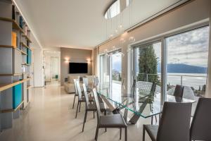 a dining room with a table and chairs and a large window at Villa Agave exclusive pool in Toscolano Maderno