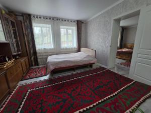 a bedroom with a bed and a red rug at Azis Hostel in Karatëbë