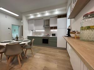 a kitchen with a table and chairs and a kitchen with white cabinets at Comfort Zone in Mestre