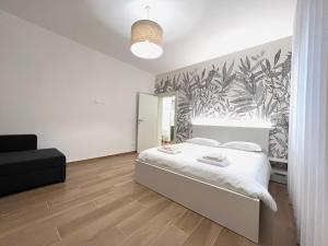 a bedroom with a white bed with a tropical wallpaper at Comfort Zone in Mestre