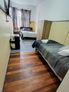 a bedroom with two beds and a wooden floor at Her Home in Purranque