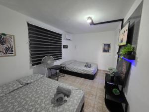 a small room with two beds and a fan at Relax en el pueblo 2 in Fajardo
