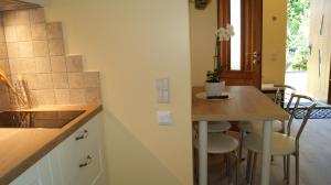 a kitchen with a counter and a table with stools at VilaFėja Private courtyard house in Palanga