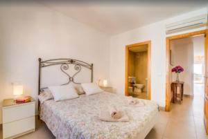a bedroom with a bed and a bathroom at Es Port penthouse in Santanyi