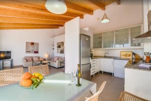 a kitchen and living room with a table and chairs at Es Port penthouse in Santanyi