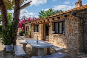 a stone house with a stone table and benches at Ses Rodes in Felanitx