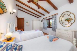 a bedroom with two beds and a mirror on the wall at Ses Rodes in Felanitx +22 photos