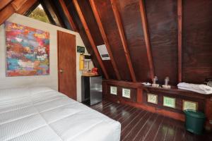 a bedroom with a white bed and wooden walls at Chalets en Santa Elena en medio del Bosque in Medellín