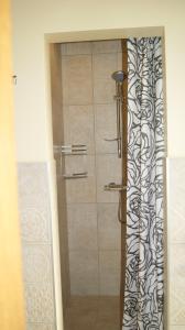 a shower with a black and white curtain in a bathroom at VilaFėja Private courtyard house in Palanga +9 photos