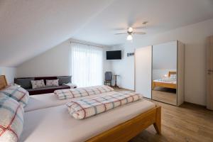 a large bedroom with two beds and a mirror at Ferienwohnungen Beilerstädtle in Oppenau +80 photos