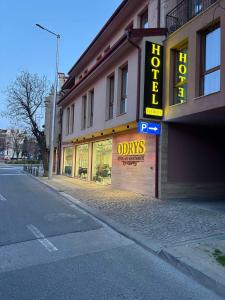 a store with a neon sign on the side of a building at Hotel Odrys in Plovdiv