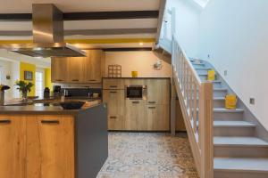 a kitchen with a staircase leading up to a kitchenasteryasteryasteryasteryasteryastery at Le clos du Verdelet vue mer piscine in Planguenoual