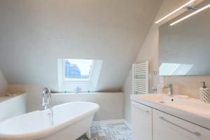 a white bathroom with a tub and a sink at Le clos du Verdelet vue mer piscine in Planguenoual +23 photos