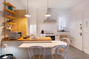 a white kitchen with a table and chairs at La filanda in Abbadia Lariana +12 photos
