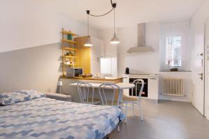 a bedroom with a bed and a table and chairs at La filanda in Abbadia Lariana
