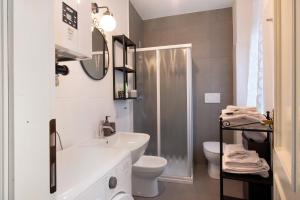 a white bathroom with a sink and a toilet at La filanda in Abbadia Lariana