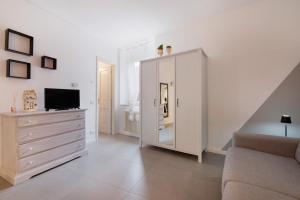 a living room with a large white cabinet and a television at La filanda in Abbadia Lariana