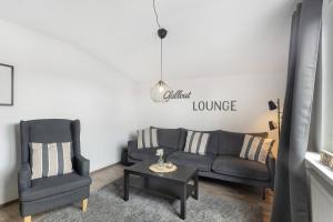 a living room with a couch and a chair and a table at Ferienwohnung Jule in Arnsberg