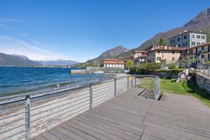 a wooden boardwalk next to a body of water at La filanda in Abbadia Lariana