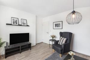 a living room with a television and a chair at Ferienwohnung Jule in Arnsberg +42 photos