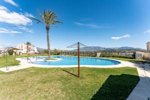 a swimming pool with a palm tree in a yard at Las Terrazas in La Cala de Mijas