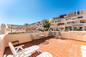 a balcony with chairs and a table and a building at Las Terrazas in La Cala de Mijas