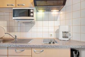 a small kitchen with a sink and a microwave at Gästehaus Gaby in Bad Bellingen +37 photos