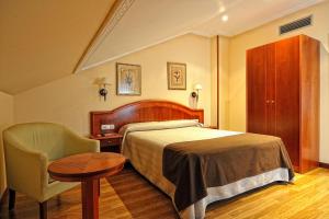 Habitación de hotel con cama, mesa y silla en Hotel Alisi en Aranda de Duero