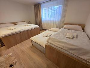 two twin beds in a room with a window at Vila Daniela in Luhačovice