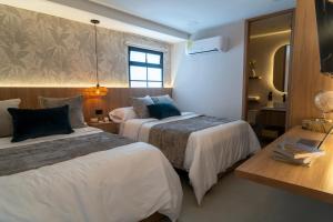 a hotel room with two beds and a mirror at Bruma Verde Casa Hotel in Medellín +45 photos