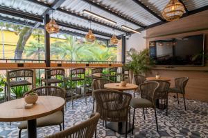 a restaurant with tables and chairs and a large window at Bruma Verde Casa Hotel in Medellín