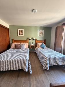 two beds in a hotel room with two beds at Spacious house just steps from the cathedral in Morelia