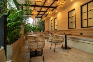 a restaurant with chairs and tables and potted plants at Bruma Verde Casa Hotel in Medellín