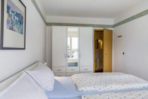a bedroom with a white bed and a mirror at Fewo Ricken am Kurpark in Willingen